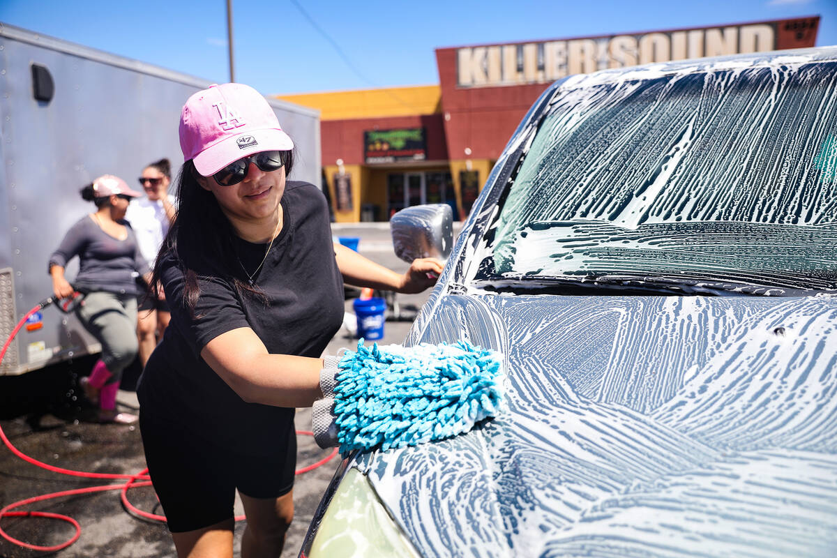 Melissa Salazar washes a car at a fundraiser for the burial of Delia Luna-Rojo and her husband ...