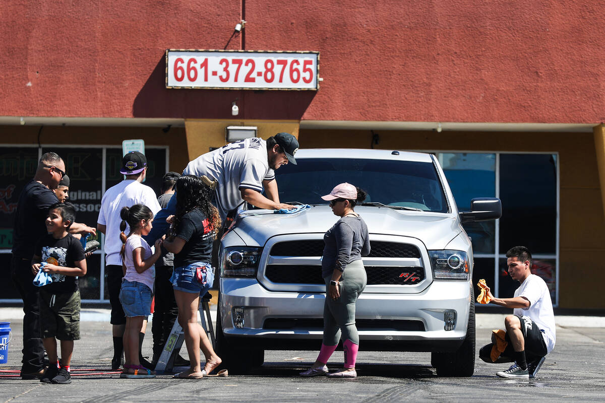 Family and friends wash a car at a fundraiser for the burial of Delia Luna-Rojo and her husband ...