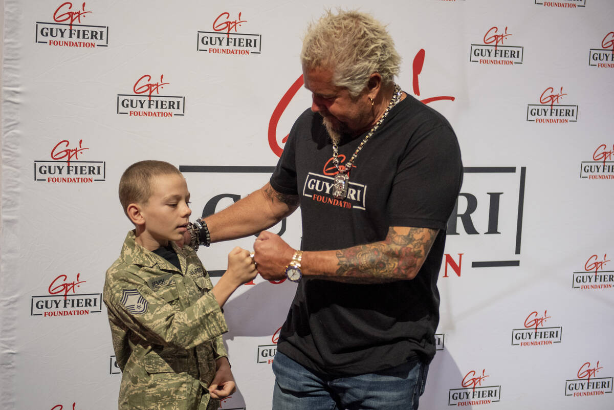 Zackary Gemik, 11, fist bumps chef and TV personality Guy Fieri during a lunch for veterans and ...