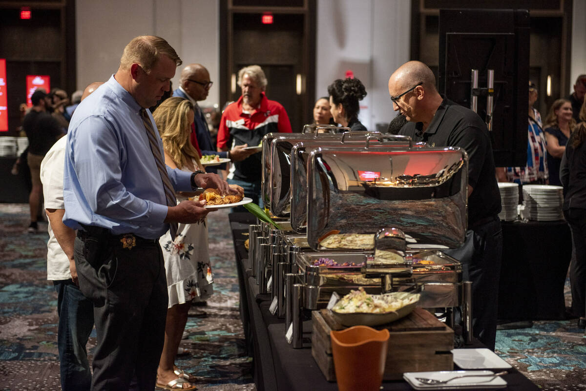 People line up for lunch during an event hosted by chef and TV personality Guy Fieri to honor v ...