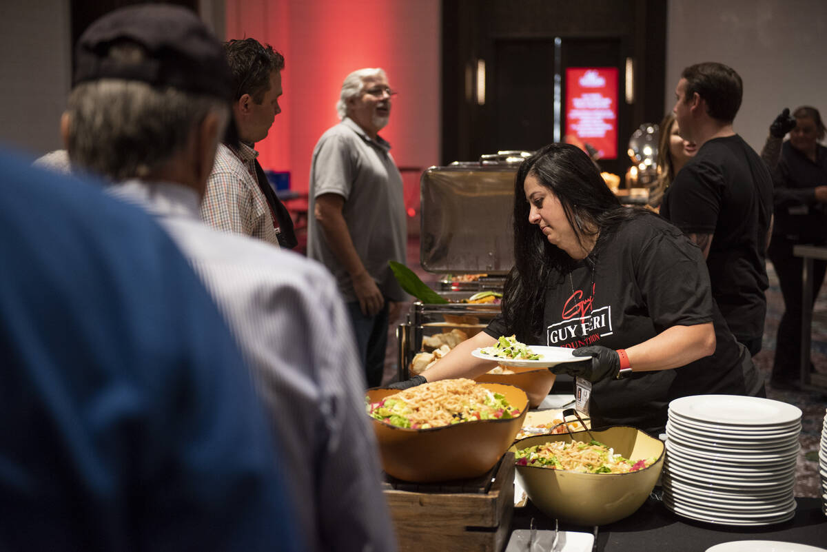 People line up for lunch during an event hosted by chef and TV personality Guy Fieri to honor v ...