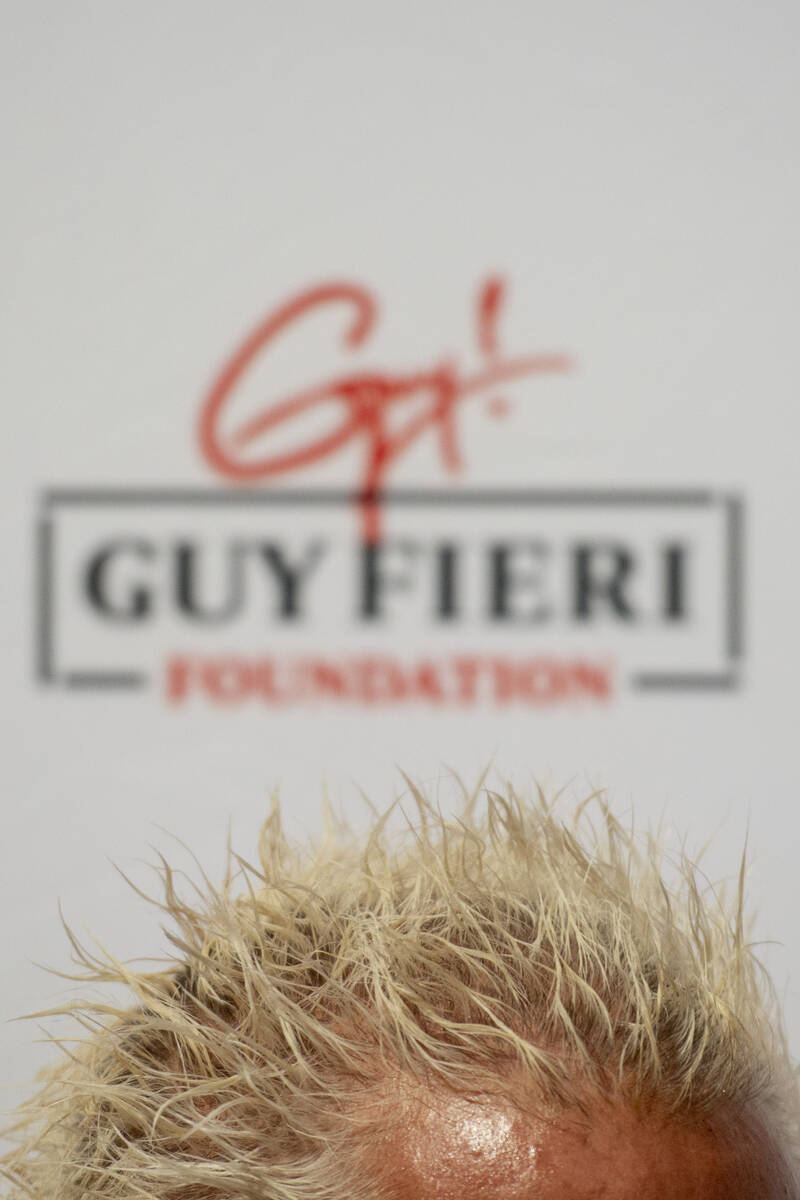 Chef and TV personality Guy Fieri talks to the media during an event honoring veterans and firs ...