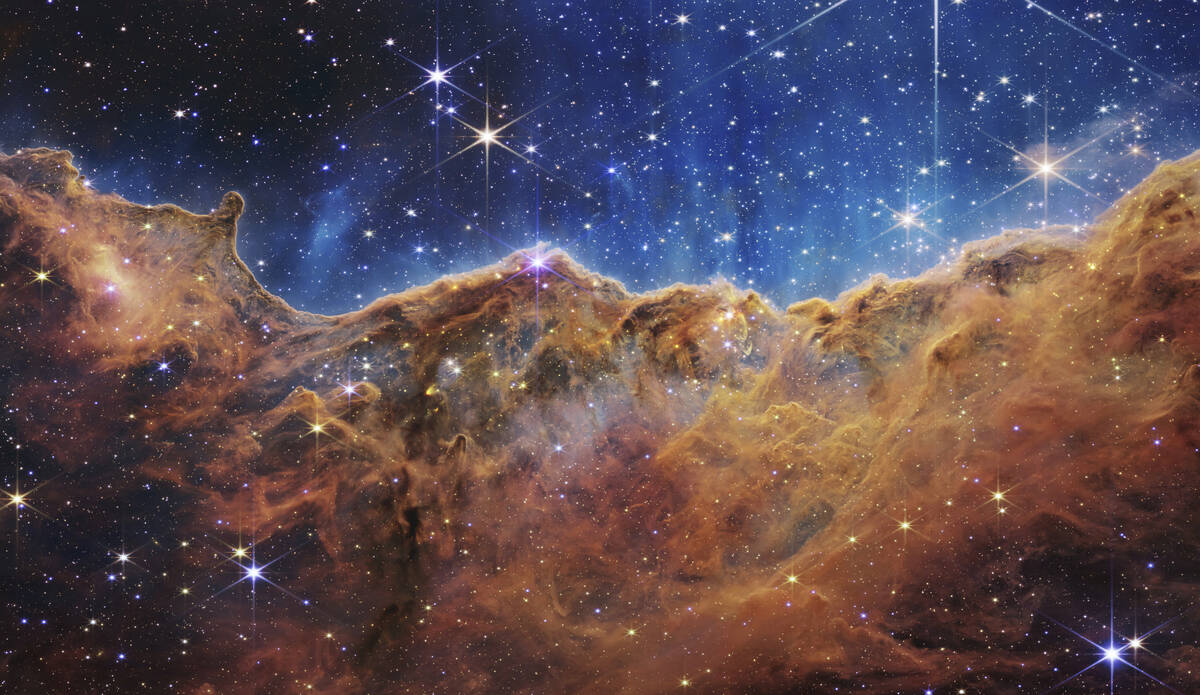 This image released by NASA on Tuesday, July 12, 2022, shows the edge of a nearby, young, star- ...
