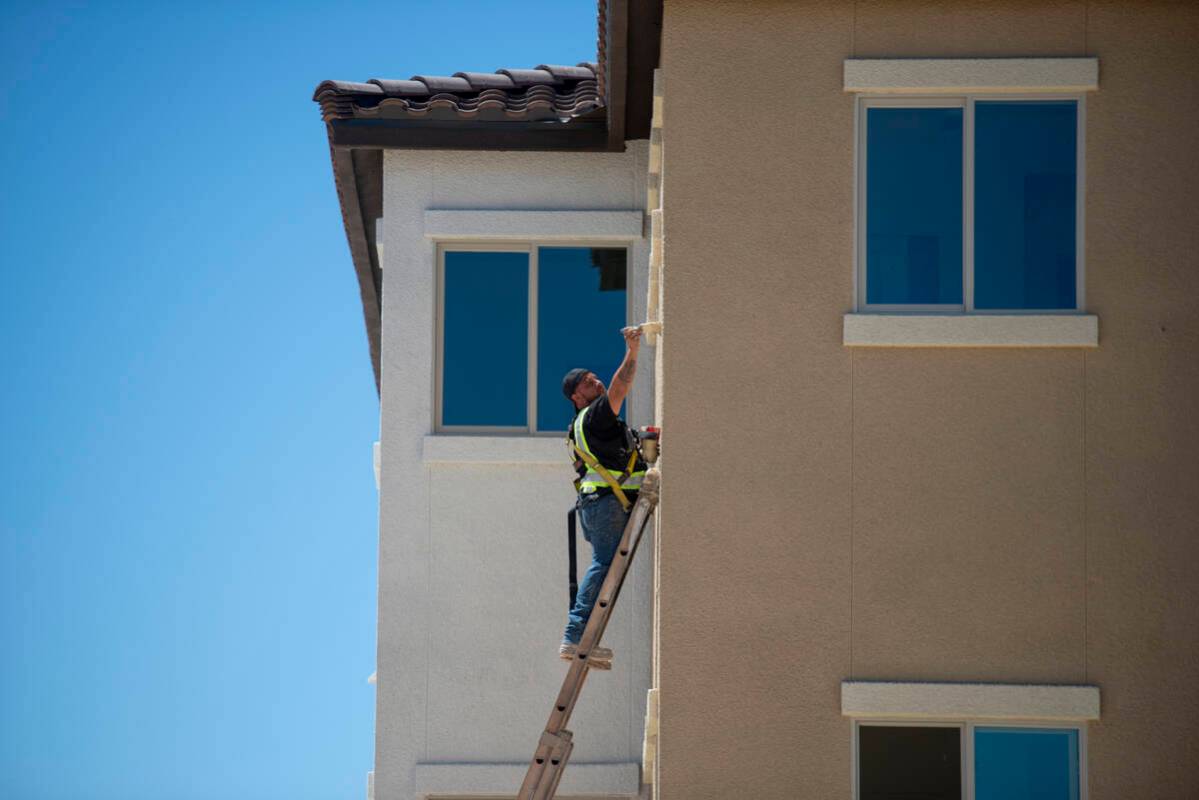 Workers put the finishing touches on a building at the Decatur Commons affordable housing compl ...