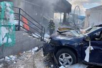 In this photo provided by the Ukrainian Emergency Service a firefighter stands among the damage ...