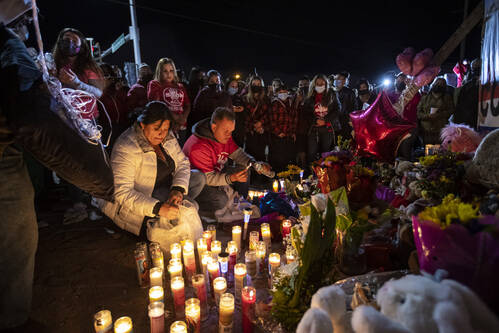 Erlinda Zacarias, left, and husband Jesus Mejia-Santana, light candles at a memorial during a v ...