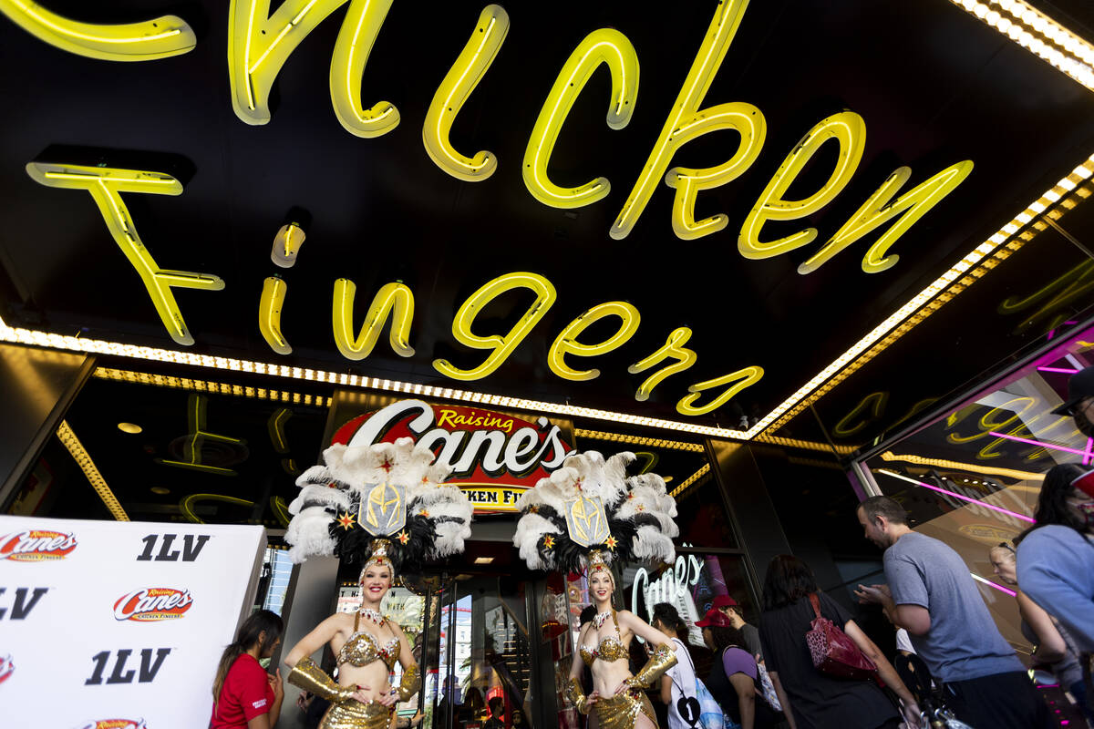 People attend the grand opening of the Raising Cane’s restaurant in the Showcase Mall on ...