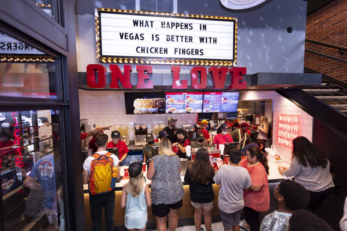 People attend the grand opening of the Raising Cane’s restaurant in the Showcase Mall in ...