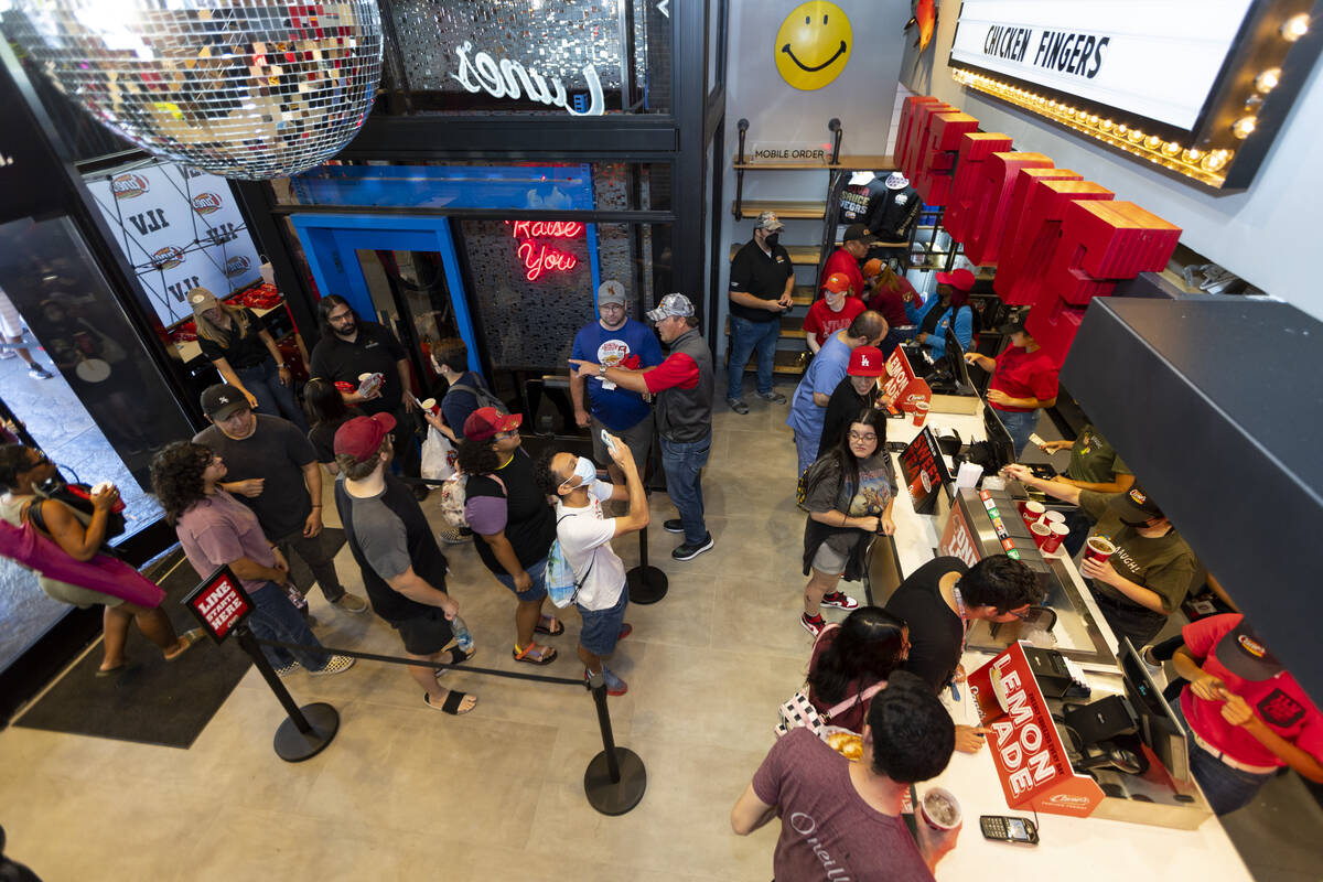 Customers order food during the grand opening of the Raising Cane’s restaurant in the Sh ...