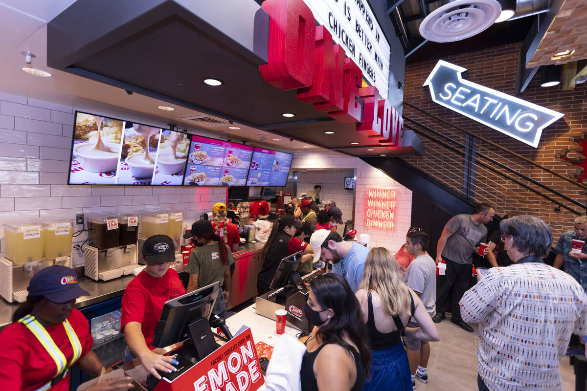 People attend the grand opening of the Raising Cane’s restaurant in the Showcase Mall in ...