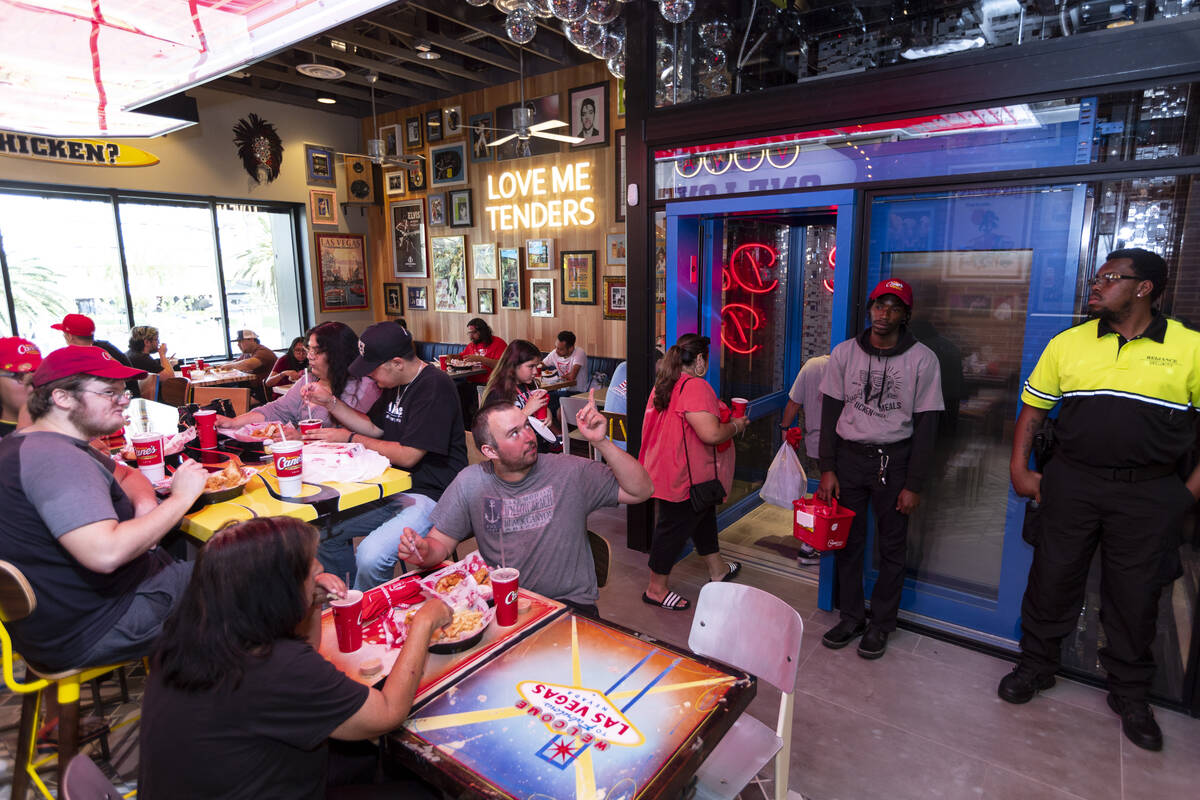 People attend the grand opening of the Raising Cane’s restaurant in the Showcase Mall in ...