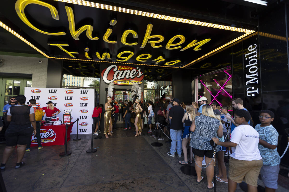 People attend the grand opening of the Raising Cane’s restaurant in the Showcase Mall on ...