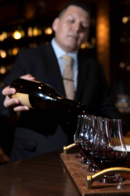 Sommelier Erick Ramirez pours a wine flight at La Cave Wine and Food Hideaway in Wynn Las Vegas ...
