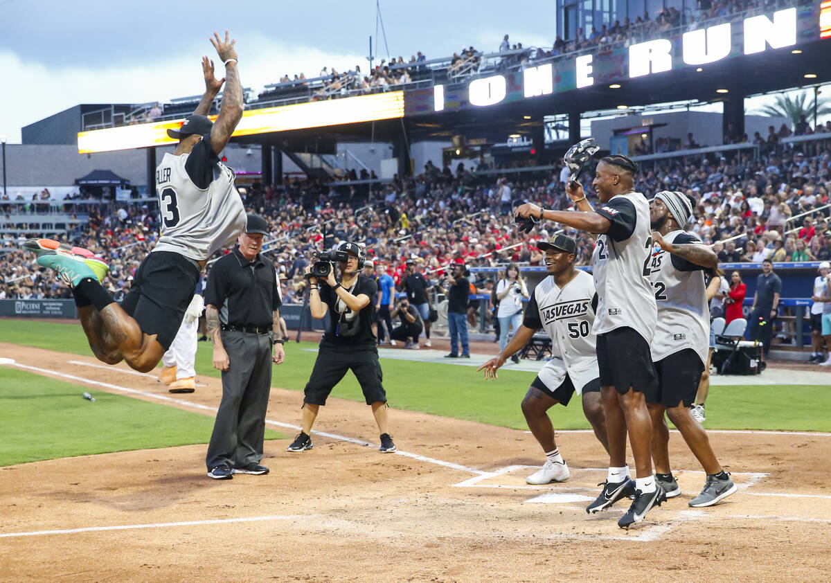 Raiders’ Darren Waller leaps for his home run as, from left, Jayon Brown, Kenyan Drake a ...