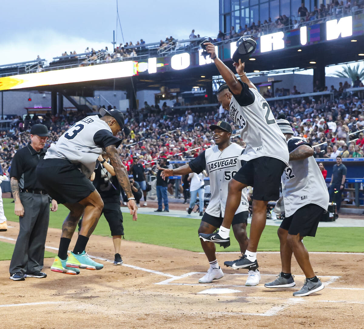 Raiders’ Darren Waller leaps for his home run as, from left, Jayon Brown, Kenyan Drake a ...
