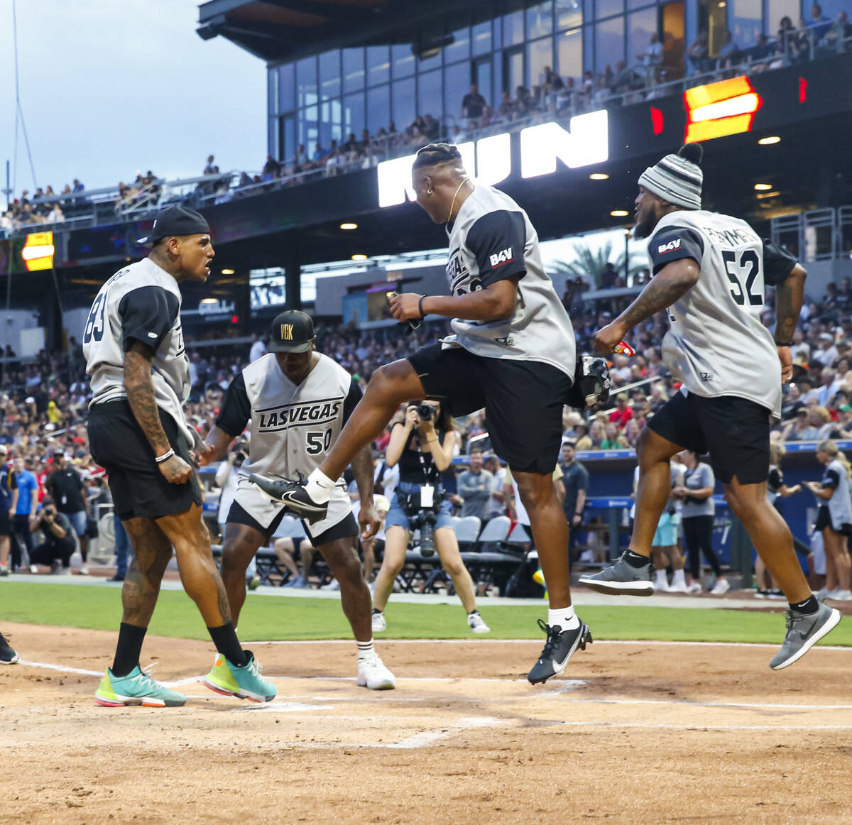 Darren Waller dari Raiders, kiri, merayakan home run-nya sebagai, dari kiri, Jayon Brown, Kenya ...