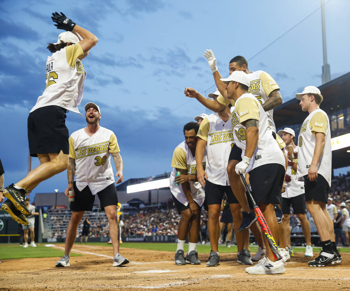Former Golden Knights player Erik Haula, left, leaps as he scores a home run while teammates ce ...