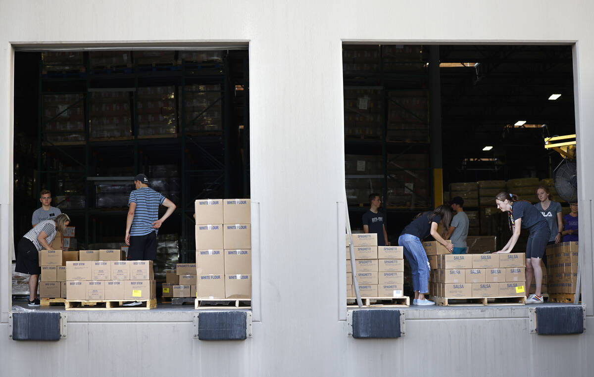 Volunteers from The Church of Jesus Christ of Latter-day Saints sort food donations to ship the ...