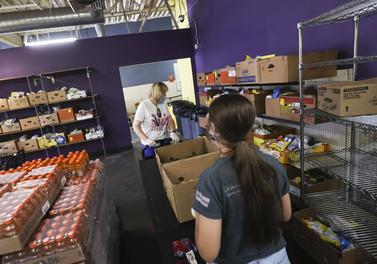 Volunteers Sara Ricciardi and her daughter Grace, 16, of Henderson, move food pantry items for ...