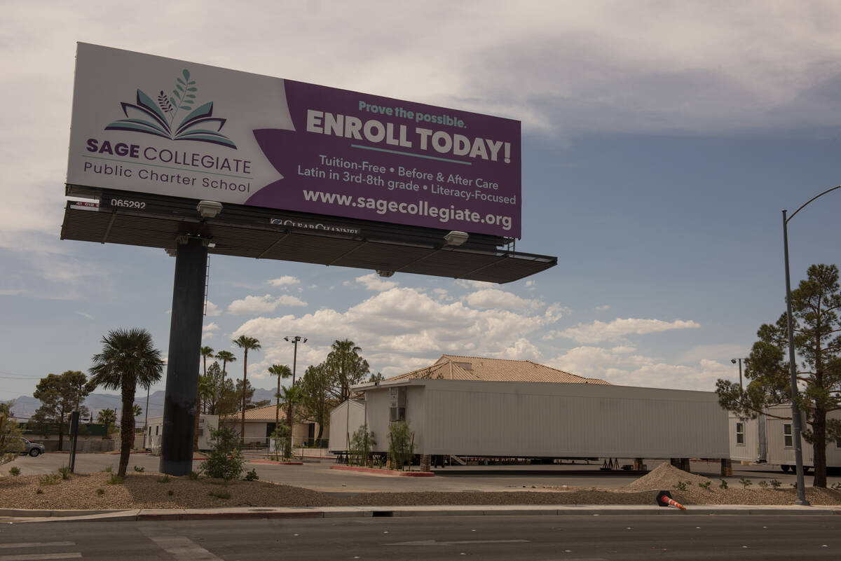 Modular classroom buildings sit in the parking lot in front of the under-construction Sage Coll ...