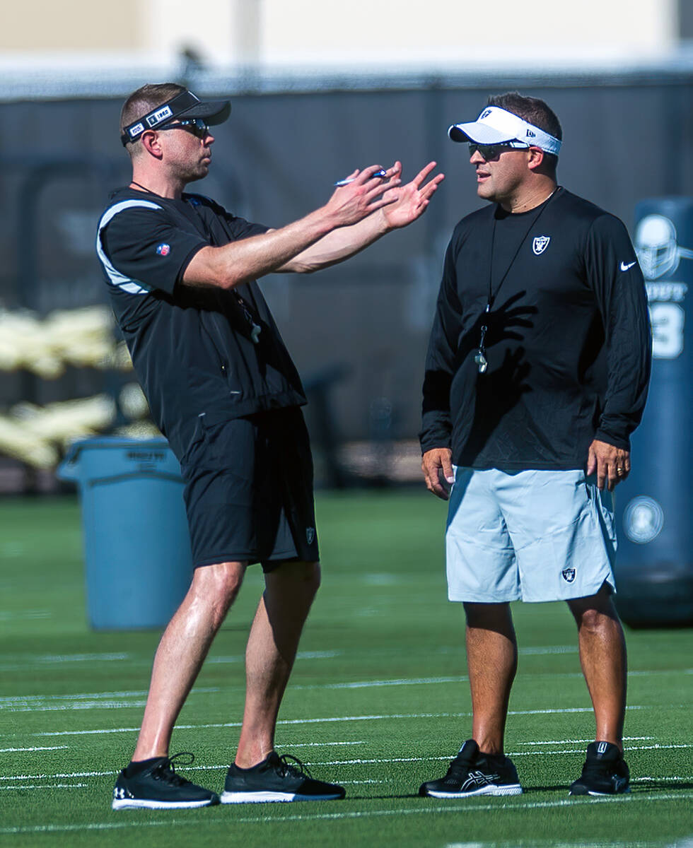 Quarterbacks coach Bo Hardegree, left, talks with head coach Josh McDaniels during Raiders firs ...
