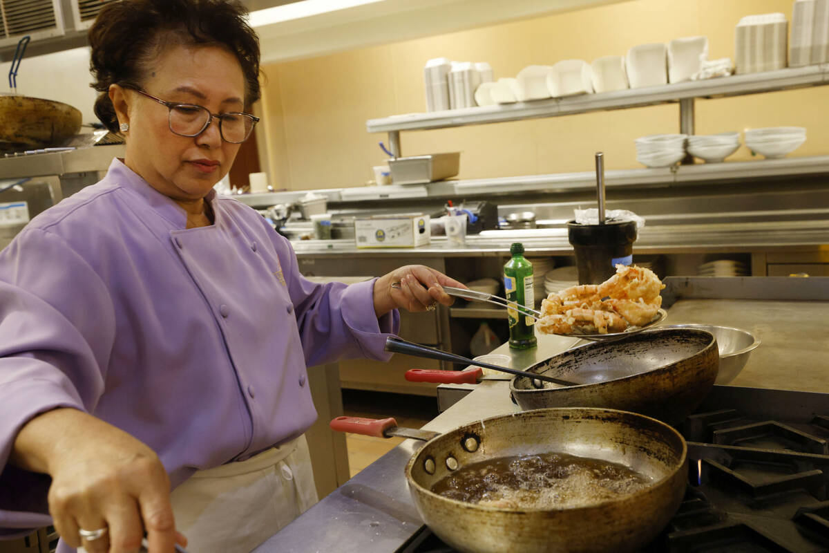 Lotus of Siam owner/chef Saipin Chutima cooks prawns, Friday, July 22, 2022, at her restaurant ...