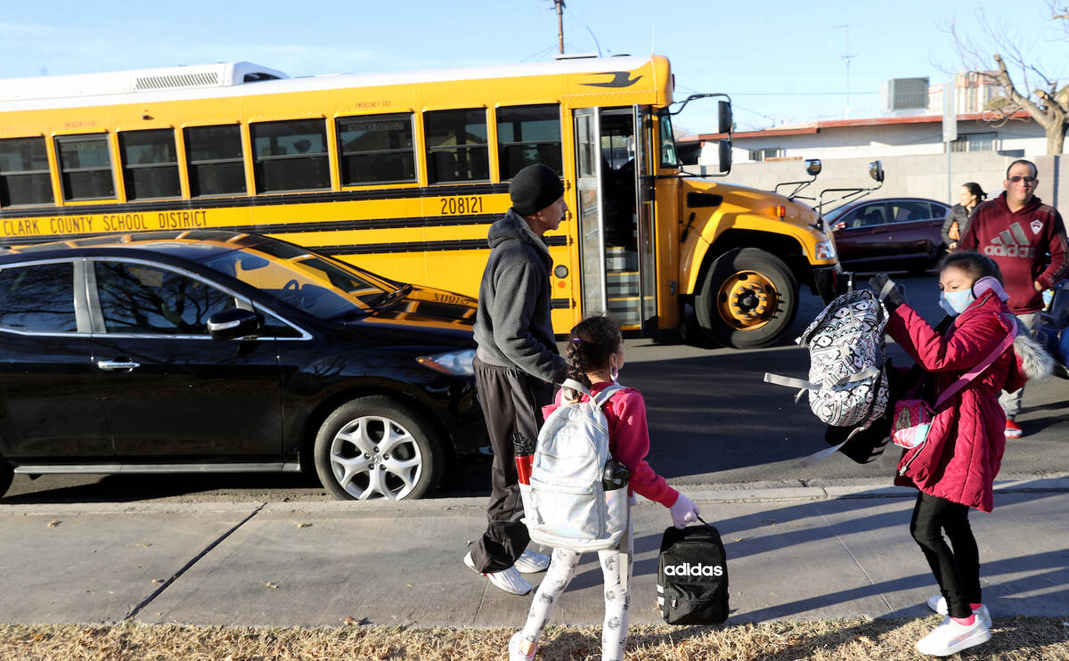 Juan Campos gets his daughter Damaris, 8 right and Diana, 7 ready for the bus on the first day ...