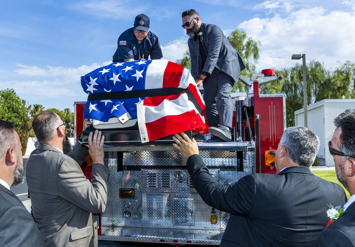 Frank Pizarro, top left, and Kevin Egbert guide the casket of Las Vegas Fire & Rescue Capt. ...
