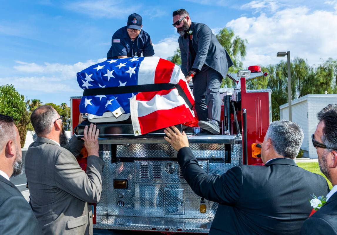 Frank Pizarro, top left, and Kevin Egbert guide the casket of Las Vegas Fire & Rescue Capt. ...
