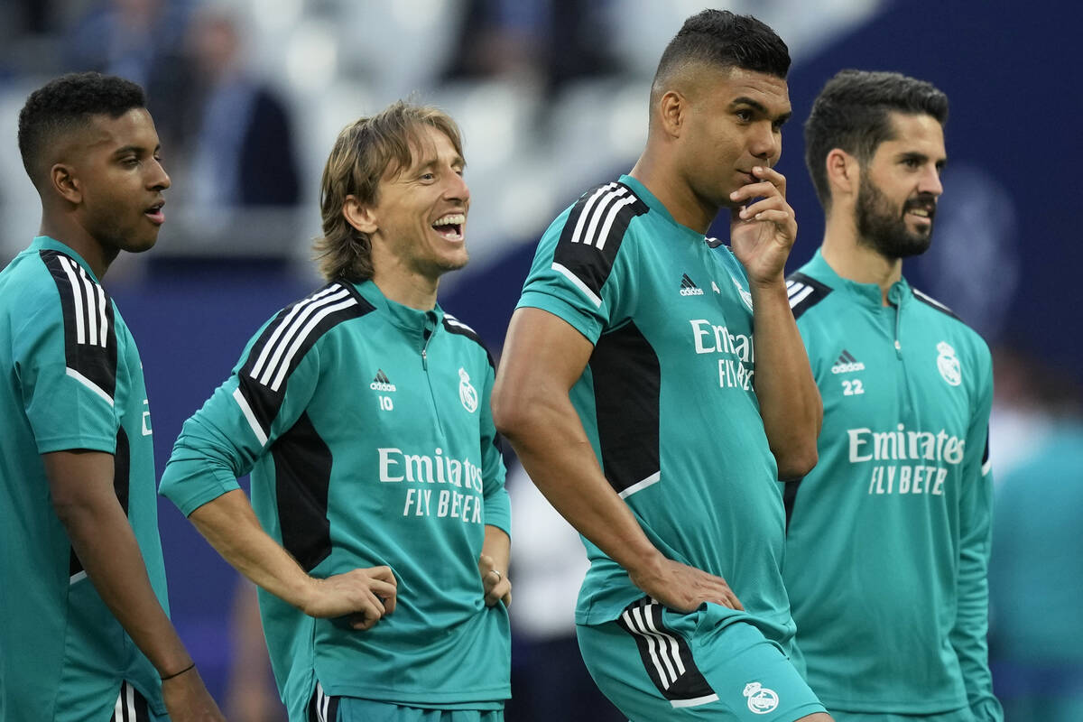 Real Madrid's Luka Modric, 2nd left, and Eder Militao, right, smile during a training session a ...