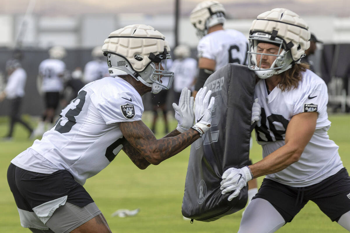 Raiders tight end Jacob Hollister (88) braces himself as tight end Darren Waller (83) makes con ...