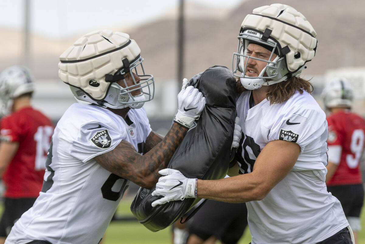 Raiders tight end Jacob Hollister (88), right, braces himself as tight end Darren Waller (83) m ...
