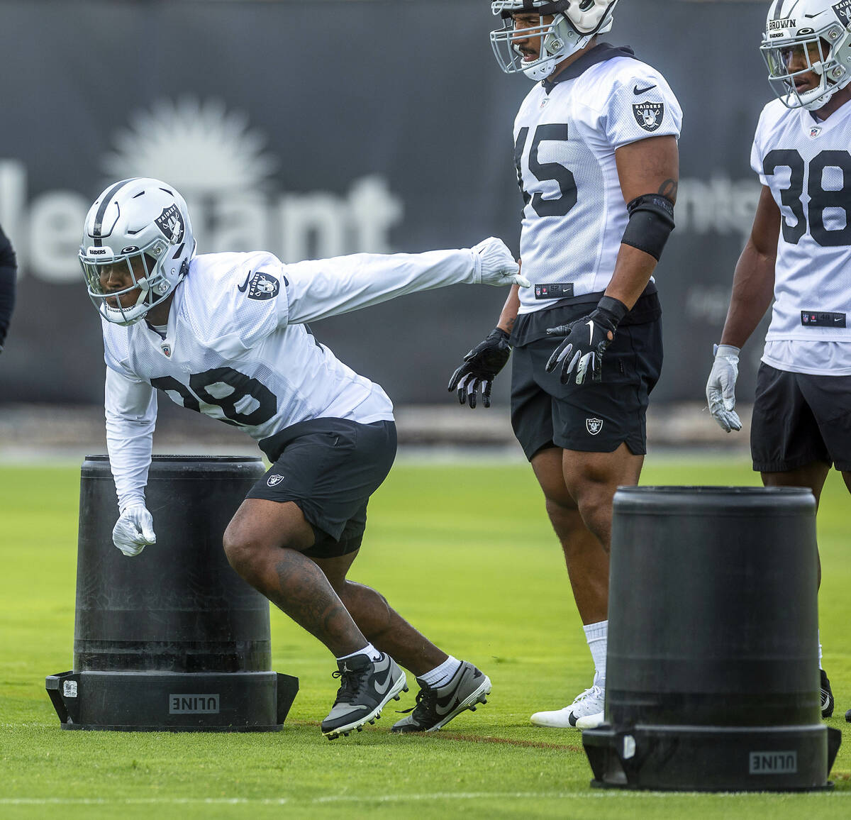 Raiders running back Josh Jacobs (28) runs a drill as teammates fullback Jakob Johnson (45) and ...