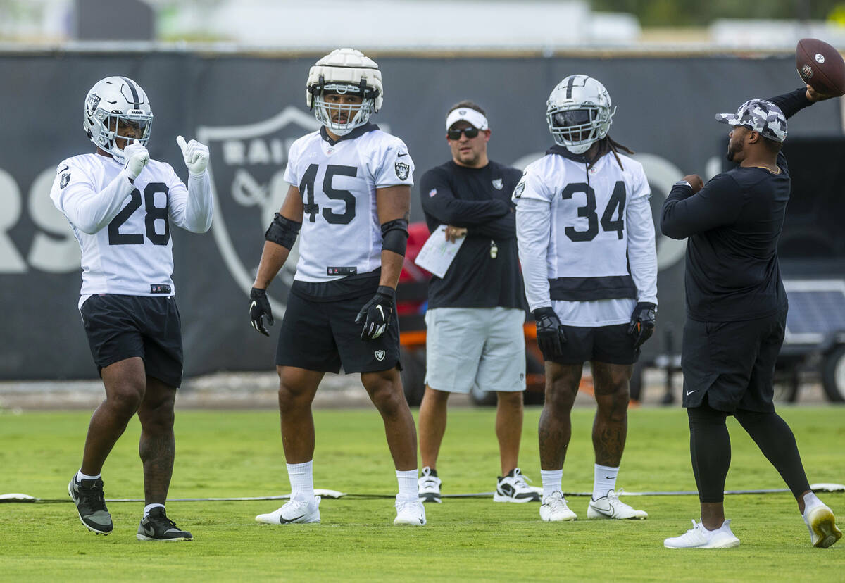Raiders running back Josh Jacobs (28) runs a drill as teammates fullback Jakob Johnson (45) and ...