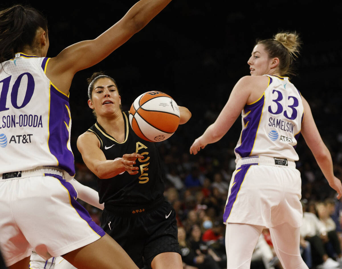 Las Vegas Aces guard Kelsey Plum (10), center, looks to pass against Los Angeles Sparks forward ...