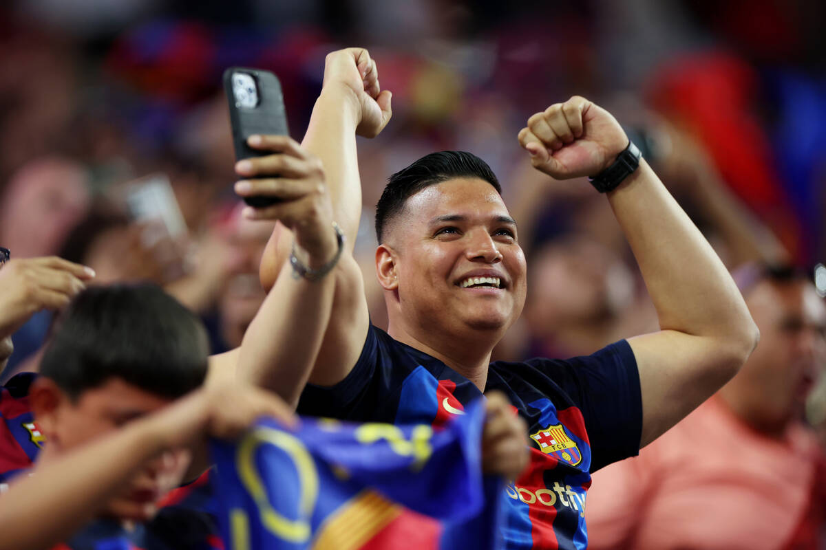 A fan celebrates a Barcelona goal in the first half of a Champions Tour soccer game against Rea ...