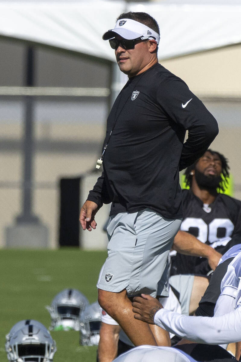Raiders head coach Josh McDaniels walks the field during the team’s training camp practi ...