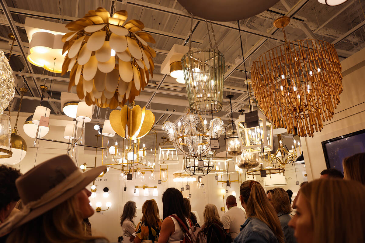 Guests on a tour about lighting at the Summer Market, a furniture and home decor trade show, at ...