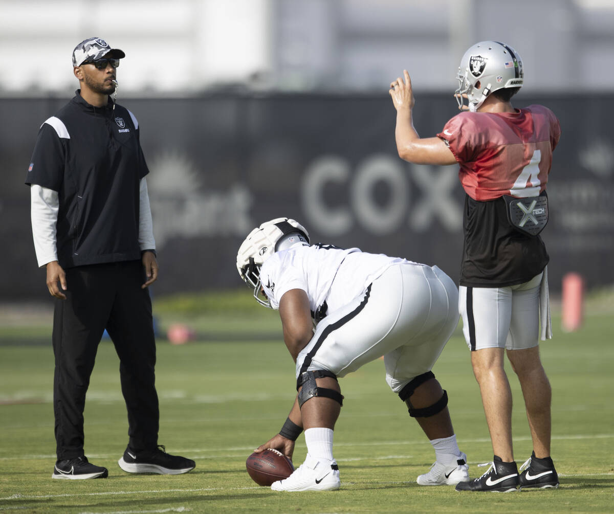 Raiders quarterback Derek Carr (4) works with offensive guard Dylan Parham (66) and offensive l ...