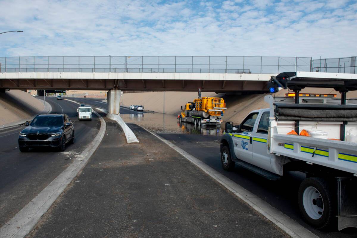 Nevada DOT workers work to clear floodwaters from West Washington Ave. near North Main St. on F ...