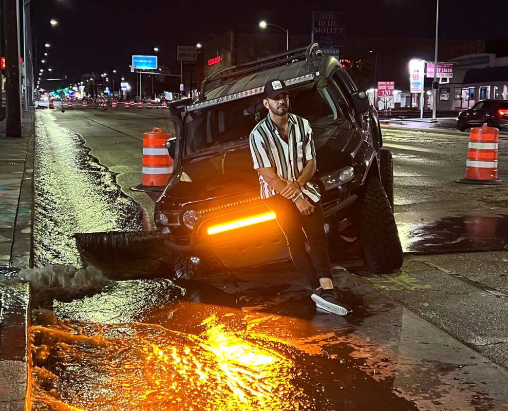 Miguel Reyes waits for a tow truck after a metal plate was missing along Charleston Boulevard i ...