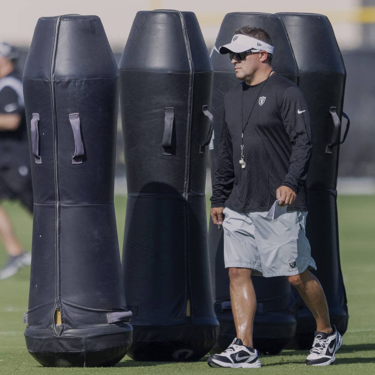 Raiders head coach Josh McDaniels walks the field during the team’s training camp practi ...