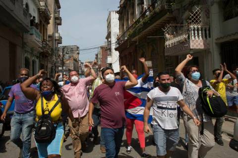 Government supporters shout slogans as anti-government protesters march in Havana, Cuba, Sunday ...