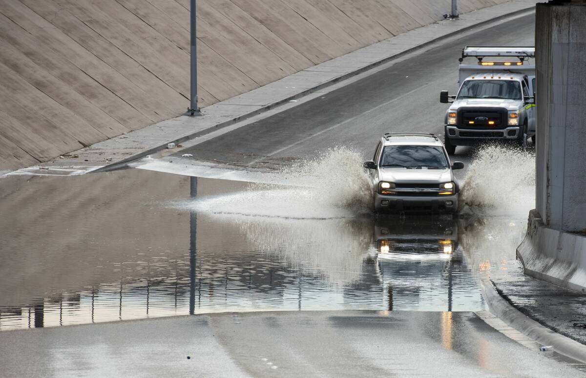 A car drives though flood waters on West Washington Ave. near North Main St. on Friday, July 29 ...
