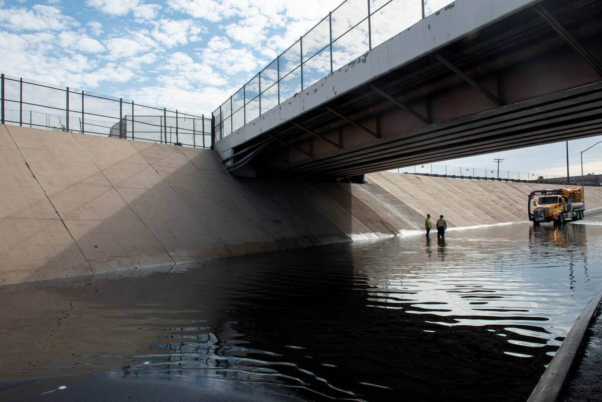 Nevada DOT workers work to clear flood waters from West Washington Ave. near North Main St. on ...