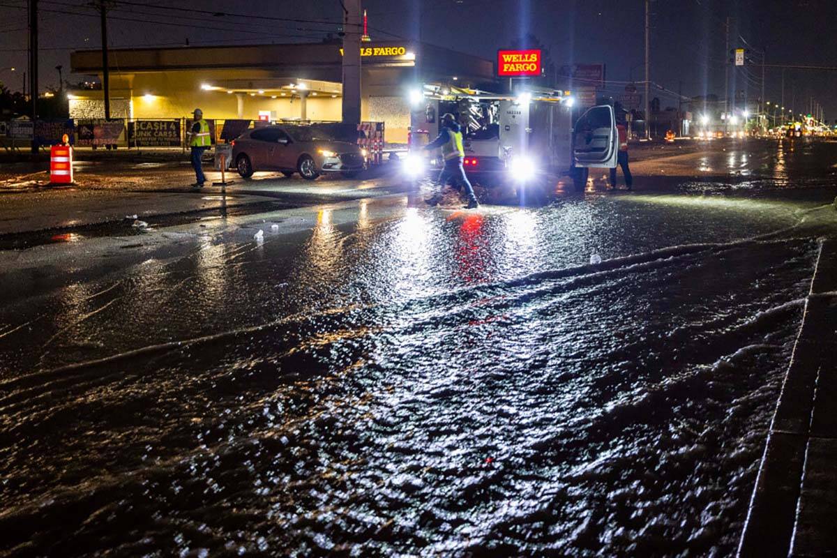 A road crew blocks the flooded Charleston Blvd. at South Spencer Street as a powerful storm mov ...