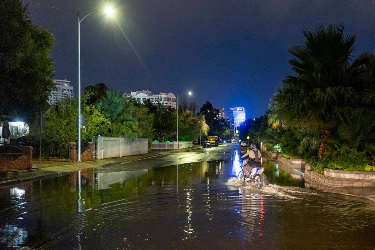 A motorcyclist rides through the flooded South Sixth Street at Sweeney Ave. as a powerful storm ...