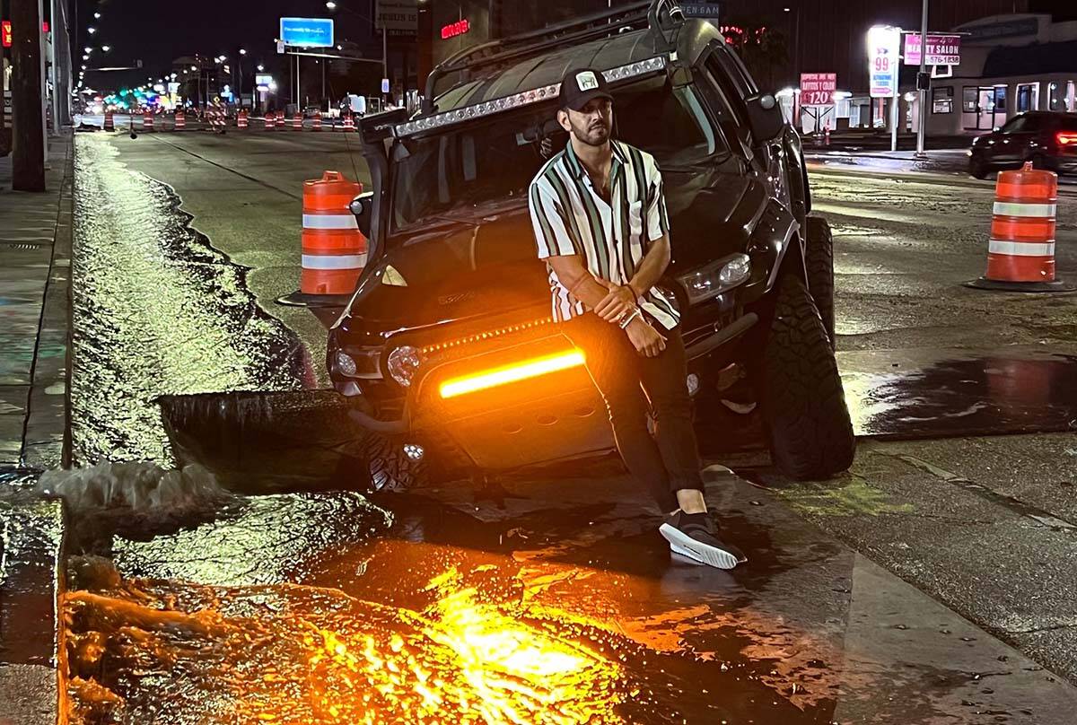 Miguel Reyes waits for a tow truck after a metal plate was missing along Charleston Blvd. and h ...