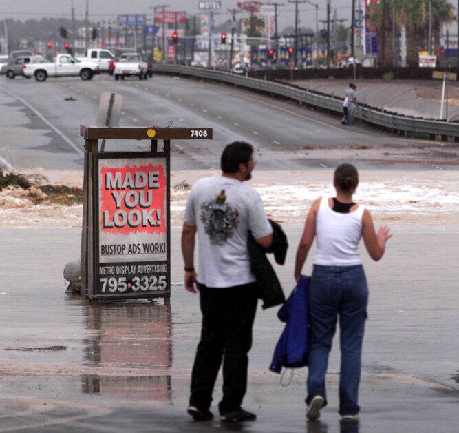 Onlookers watch the floodwaters crossing Boulder Highway near Sahara Avenue on July 8, 1999. (L ...
