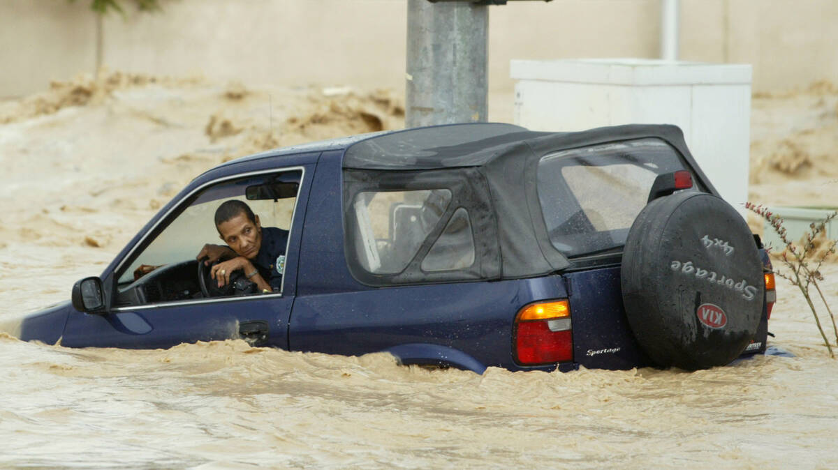 Juliette Lopez sits in her car surrounded by floodwaters in Las Vegas on Aug. 19, 2003. The wat ...